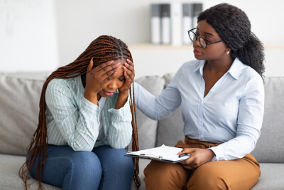 Upset black lady with nervous breakdown consulting psychologist